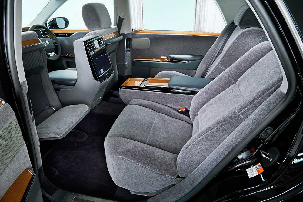 Rear passenger area and passenger comfort is a always major design factor in the Toyota Century. Rear controls and HVAC are up high, a much more effective position. Rear trays are another element which inspires the JDM VIP Crowd. Also notice the interior specified in Wool, leather is available but who needs leather when you can have wool. - 2018 Toyota Century HYBRID The Ultimate in JDM Luxury